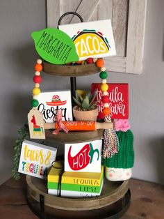 a three tiered tray with various items on it and the words taco written on them