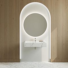 a white sink sitting under a round mirror