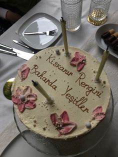 a birthday cake with candles and flowers on it