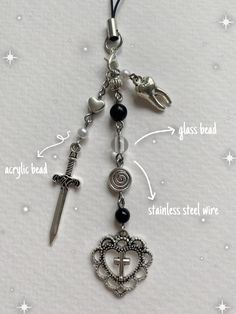 a key chain with charms attached to it and an arrow on the front, cross in the middle