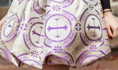 a close up of a person wearing a dress with purple and white designs on it