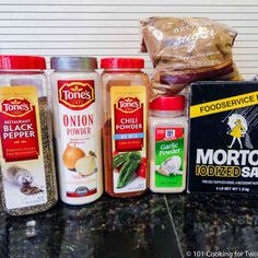 spices and seasonings are lined up on a counter top next to a bag of flour