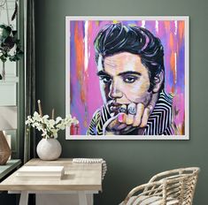 a painting of elvis presley on a green wall above a white table with a wicker chair