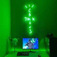 a desk with a computer, keyboard and mouse in front of a neon green wall