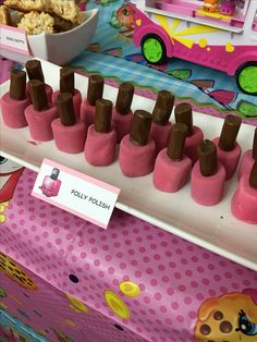 there are many pink cones on the table with chocolate sticks sticking out of them,