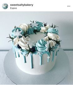 a white cake with blue icing and flowers on top