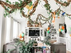 a living room filled with lots of plants and balloons hanging from the ceiling above it