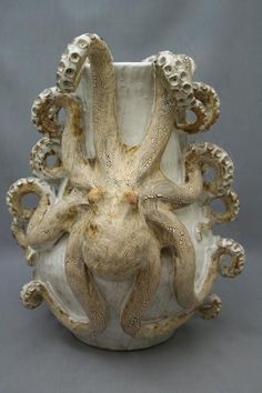 an octopus sculpture sitting inside of a white vase