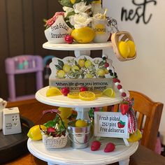 a three tiered cake stand with lemons and strawberries on the top shelf