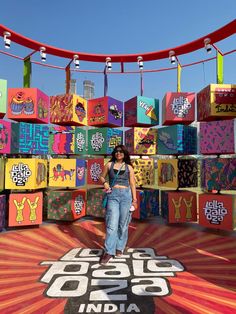 a woman standing in front of an array of brightly colored boxes with the words india on them