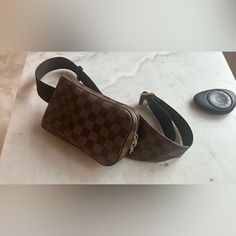 Like New, Only Worn Once Comes With Dust Bag Chic And On-Trend Louis Vuitton Geronimos Sling Bag Rendered In The House's Iconic Damier Ebene Checked Coated Canvas With Dark Brown Leather Accents, Finished With Gold-Tone Brass Hardware. The Sling Bag Silhouette Is Meant To Be Worn Diagonally Across The Body And Features An Adjustable Canvas Strap For Comfortable Carry. Features: Adjustable Nylon Strap Zip-Around Closure Coated Canvas Canvas Lining Gold Hardware Details: Length: 4.25" (10 Cm) Height: 7.5" (19 Cm) Depth: 2" (5 Cm) Bag Silhouette, Louis Vuitton Damier Ebene, Leather Accents, Damier Ebene, Dark Brown Leather, Brass Hardware, Sling Bag, Louis Vuitton Damier, Gold Hardware