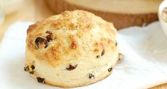 a muffin sitting on top of a white napkin next to a bowl of oatmeal