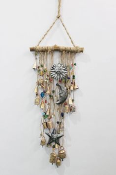 a wind chime hanging on the wall with bells and bells attached to it's sides