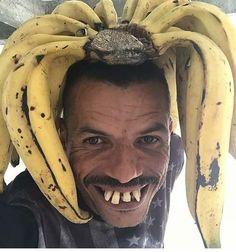 a man wearing a bunch of bananas on top of his head with teeth and mustache