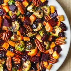 a white plate topped with brussel sprouts and roasted vegetables