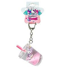 a key chain with a pink cup on it and a cartoon character in the middle