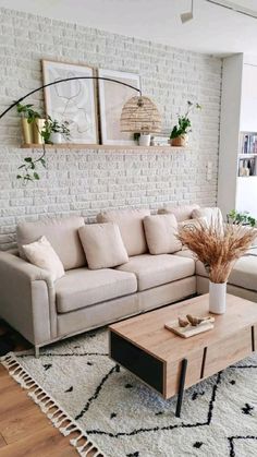 a living room with a couch, coffee table and potted plants