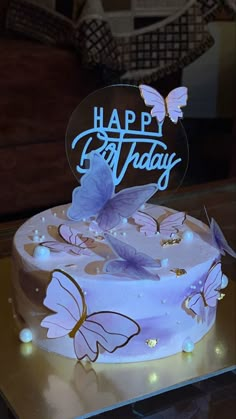 a birthday cake decorated with butterflies and the words happy birthday on it's frosting