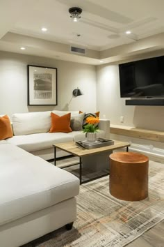 a living room filled with furniture and a flat screen tv mounted on the wall above it