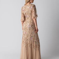 Radiate in the Natalie Gown, a blush-hued masterpiece adorned with pastel florals and sparkling sequins. Its elegant V-neck and flutter sleeves complement the fitted bodice, flowing into a gently flared hem for a touch of romance. Perfect for bridesmaids or spring formals, the Natalie is a blend of sophistication and whimsy. Embrace the enchantment of the Natalie for your next memorable occasion. Dress material is Tulle 100% Polyester.   Dry Clean Only by a specialist dry cleaner unless otherwise instructed on the care label. Steam your item or iron on a silk setting for best results. All items are embroidered and most often by hand so handle the beads with care as we cannot guarantee beads from coming off. Spring Formal, April Birthstone Jewelry, March Birthstone Jewelry, Silk Set, Gifts For New Mums, Pearl Jewellery Earrings, Alternative Wedding, Eye Jewelry, Fine Jewelry Gift