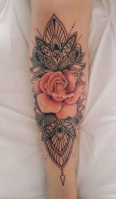 a woman's leg with a rose tattoo on her left arm and an intricate design