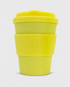 a yellow coffee cup sitting on top of a white table