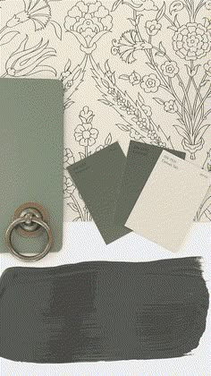 some black and white paint next to an open notebook with a ring on the cover