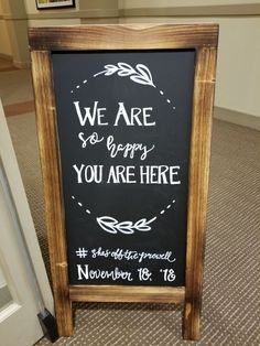 a sign that says we are so happy you are here next to a door in a room