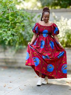 A beautiful statement dress with side pockets in a contemporary African print in a vibrant red with a bold floral pattern. It has smocking from the bust to the waist with a full skirt to the dress and adjustable exaggerated puff sleeves which can be worn off or on shoulder. An easy to wear pull on piece that may be styled for an informal outing or a formal occasion by selecting the appropriate accessories and footwear.100% Cotton. Handmade in Ghana. HAVE YOU CHECKED YOUR MEASUREMENTS AGANST THE Dress With Puff Sleeves, Maxi Skirt Dress, Statement Dress, African Design Dresses, Jumpsuit Trousers, African Design, Full Skirt, Vibrant Red, Skirt Top