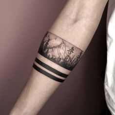 a man's arm with mountains and trees on it