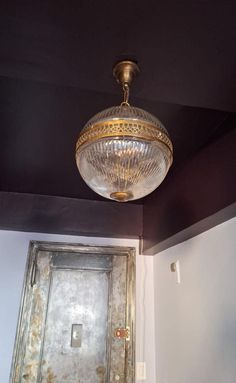 a light fixture hanging from the ceiling in a room with white walls and black ceilings