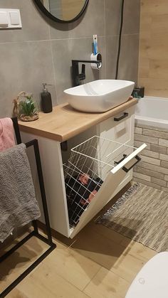 a bathroom with a sink, mirror and towel rack on the wall next to the bathtub