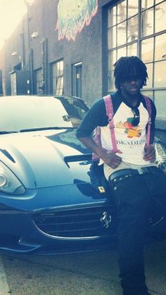 a man standing next to a blue sports car