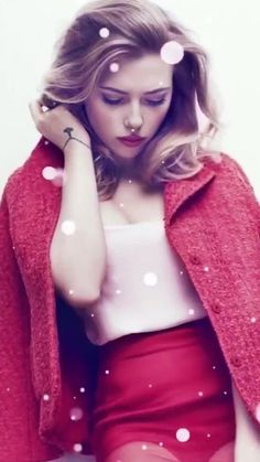 a woman sitting on top of a bed wearing a red jacket and skirt with snow falling around her