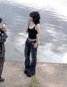 two people standing near the water taking pictures