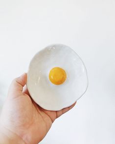 a person holding an egg in their hand