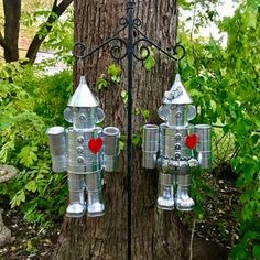 two tin cans are attached to a tree in the woods, with hearts on them