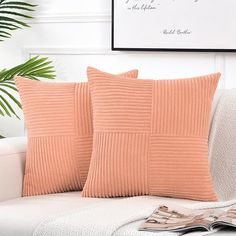 two peach colored pillows on a white couch