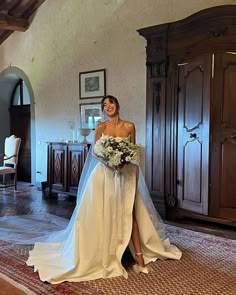 a beautiful woman in a wedding dress posing for a photo with her bridal gown