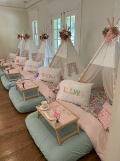 a room filled with lots of pillows and teepee tents