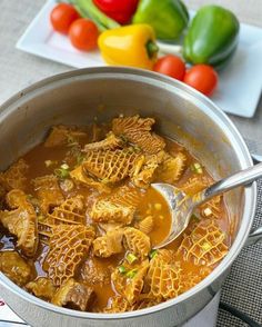 a pot filled with pasta and sauce next to vegetables