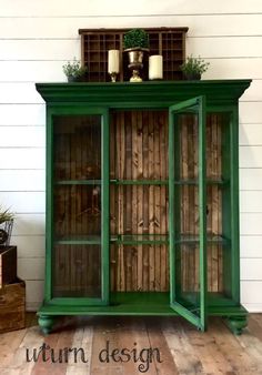 a green cabinet sitting on top of a wooden floor