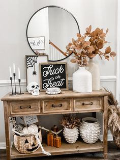 a wooden table topped with a mirror next to a vase filled with flowers and candles