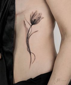 a woman's stomach with a flower tattoo on her side and the bottom part of her body