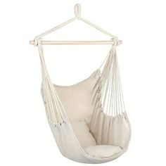 a white hammock chair hanging from a wooden hanger with pillows on it