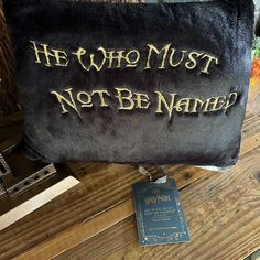 a harry potter pillow that says he who must not be named is on the table