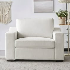 a living room with a white chair and rug