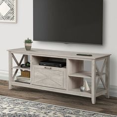 a flat screen tv sitting on top of a wooden entertainment center