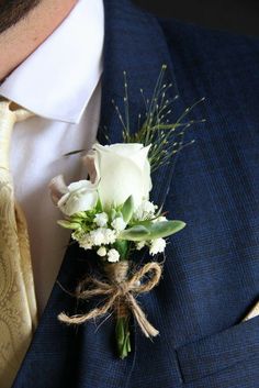 a man wearing a suit and tie with a boutonniere on his lapel