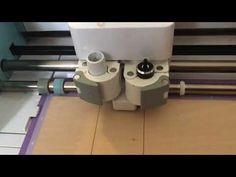 a machine that is cutting some material on the floor with it's rollers